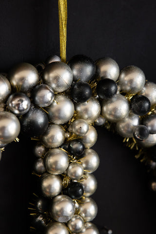 Close-up of the Peace Wreath hanging on a black wall.