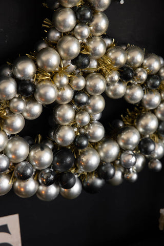 Detail shot of the Peace Wreath hanging on a black wall.