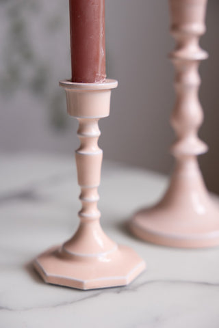 Detail shot of the Short Pink Enamel Cast Style Candlestick Holder displayed on a white table, with the tall version in the background.