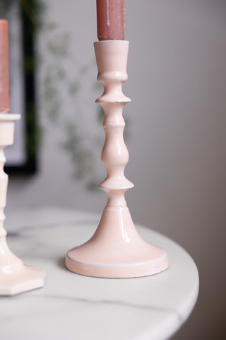 Detail shot of the Tall Pink Enamel Cast Style Candlestick Holder displayed on a white table.