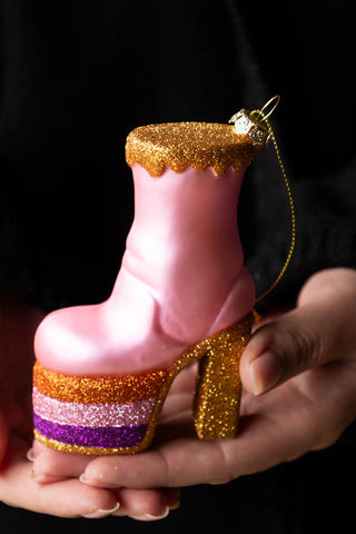 The Pink Glass Heeled Boot Christmas Tree Decoration being held in a model's hands.