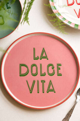 The Pink La Dolce Vita Plate styled with other plates, a spoon and greenery.