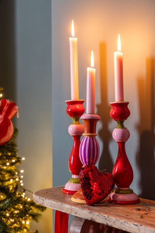 red and pink candlesticks with pink dinner candles styled on a fireplace.