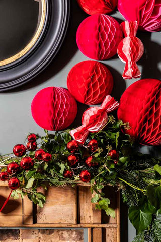 Image of the Set Of 3 Pink & Red Honeycomb Sweets styled next to pink and red christmas decorations over a wooden mantlepiece.