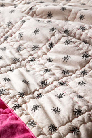 Close-up of the star print side of the Reversible Hot Pink Star Throw.