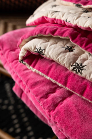 Close-up of the folded Reversible Hot Pink Star Throw.