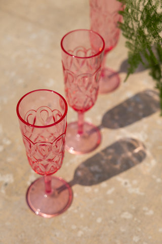 Three of the Pretty Embossed Pink Champagne Glasses styled in a row on an outdoor table, seen from above.