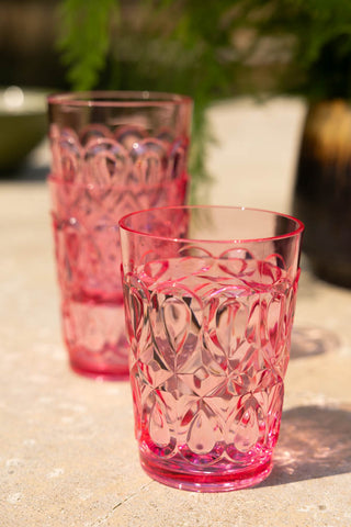 A group of 3 of the Pretty Embossed Pink Water Tumbler styled stacked together on an outdoor table.