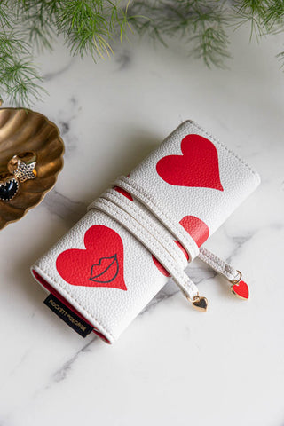 The Queen of Hearts Playing Card Jewellery Case displayed on a marble surface with a trinket dish, jewellery and a plant.