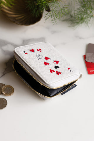 The Queen of Hearts Playing Card Purse displayed open on a marble surface, styled with coins, cards and a plant.