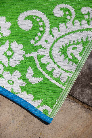 Detail shot of the corner of the Recycled Vintage Design Outdoor Rug in Green.