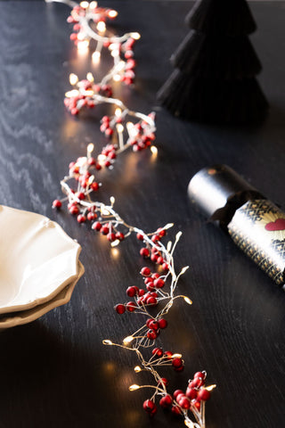 Beautiful red berries on a light chain with lit light buds.