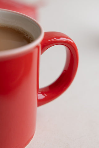 Close-up of the handle of a red ceramic mug