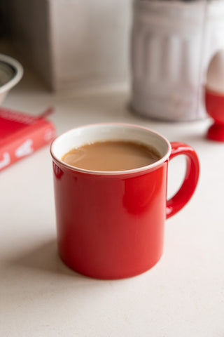 Red ceramic mug filled with tea