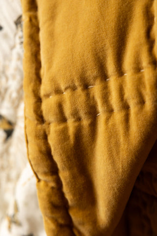 Close-up shot of the gold side of the Reversible Gold Rock & Rose Throw.