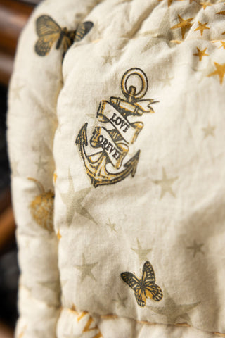 Close-up of the anchor motif on the Reversible Gold Rock & Rose Throw.