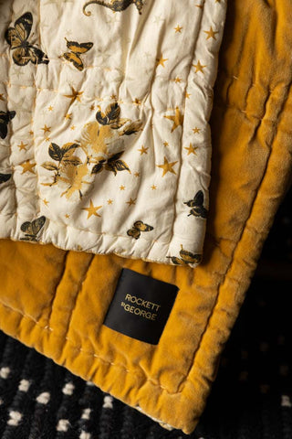 Close-up of the Reversible Gold Rock & Rose Throw, showing both sides of the design.