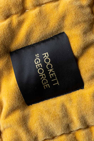 Close-up of the Rockett St George logo on the Reversible Gold Rock & Rose Throw.