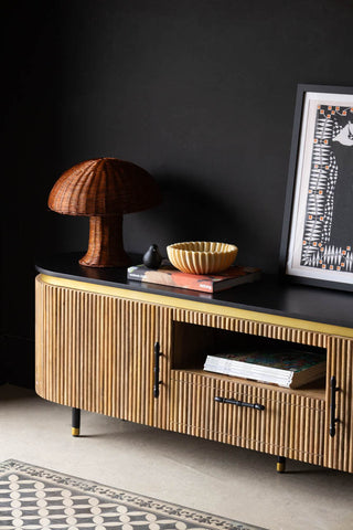 Close-up of the Ribbed TV Unit styled in front of a dark wall with various home accessories.