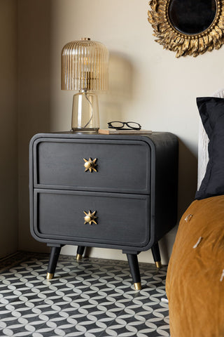 The Ringo Bedside Table styled next to a bed with a lamp, book and a pair of glasses on.