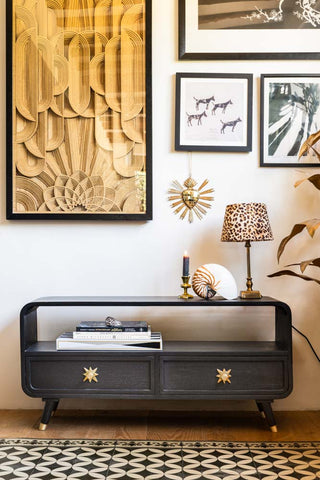 The Ringo TV Unit in front of a wall with various art prints, styled with various decorative home accessories.