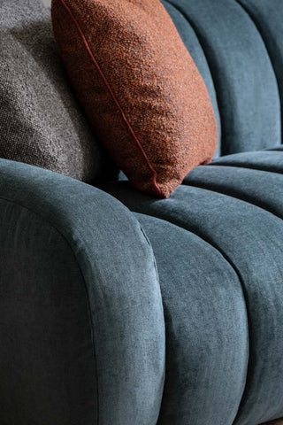 Close-up of the Beautiful Blue Roll Back 3-Seater Sofa, styled with some cushions on.