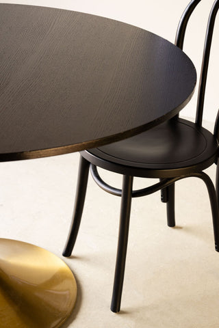 Detail shot of the Round Dining Table styled with a chair next to it.