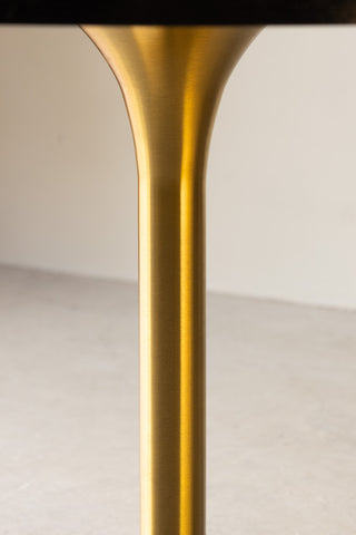 Detail shot of the gold leg of the Round Dining Table.