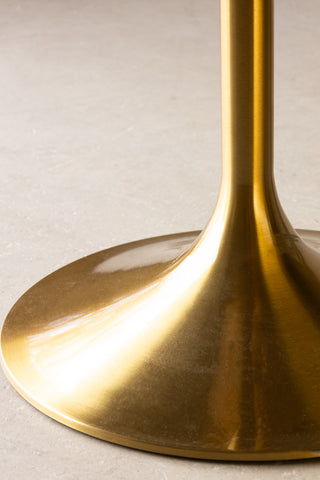 Detail shot of the gold base of the Round Dining Table.