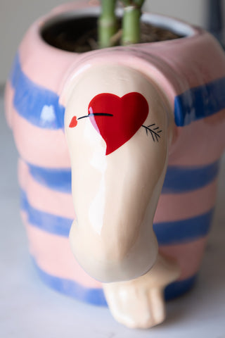 Decorative sailor ceramic pot with detailed red heart tattoo on its arm, filled with a jade plant and styled on a white table.