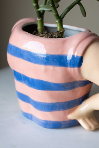 Charming sailor-style ceramic pot featuring a striped pattern t-shirt in blue and pink and whimsical arms, perfect for adding personality to plants.