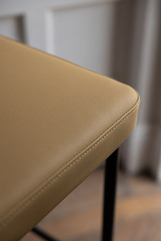 Close-up image of the Sand Faux Leather Roll Back Bar Stool