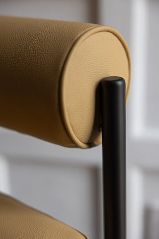 A close up image of the back rest on the Sand Faux Leather Roll Back Bar Stool