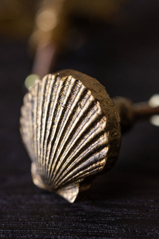 The Scallop Knob - Gold displayed on a black table.