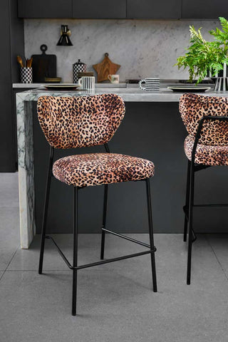 The Set Of 2 Bar Stools in Leopard Print Velvet styled in a kitchen next to a breakfast bar.