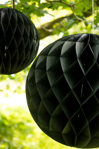 Set Of 2 Black Honeycomb Ball Decorations hanging from a tree close up