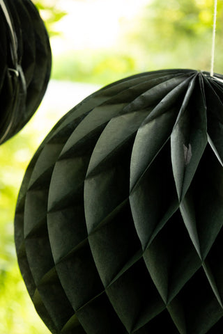 Set Of 2 Black Honeycomb Ball Decorations hanging from a tree close up