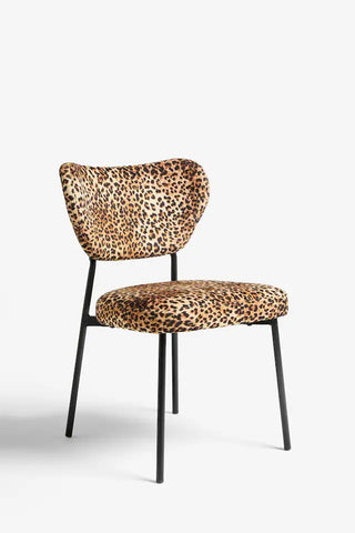 A leopard print dining chair seen from an angle, in front of a plain background.