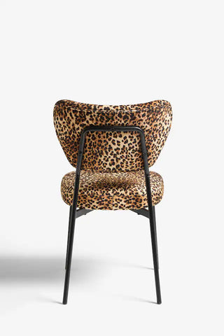 A leopard print dining chair seen from the back, on a plain background.