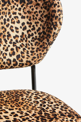 Close-up of the seat/back of a leopard print dining chair.