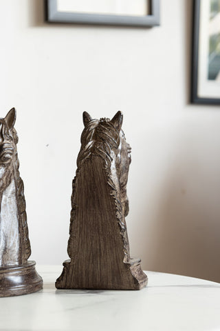 The reverse side of one of the Set Of 2 Horse Head Bookends, displayed on a table with the other bookend to the side.