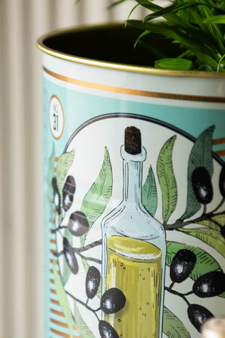 Detail shot of the top of one of the Set Of 2 Olive Oil Storage Tins - Large with a plant inside.