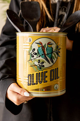 One of the Set Of 2 Olive Oil Storage Tins being held with utensils inside.