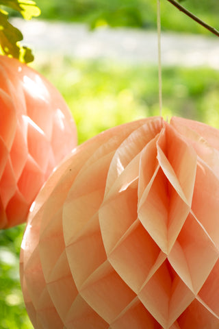 Set Of 2 Peach Honeycomb Ball Decorations hanging in tree detail