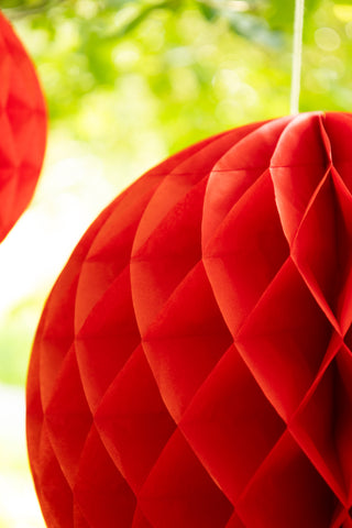 Set Of 2 Red Honeycomb Ball Decorations hanging from tree detail