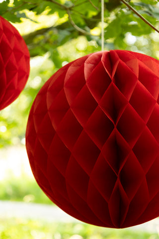 Set Of 2 Red Honeycomb Ball Decorations hanging from tree close up