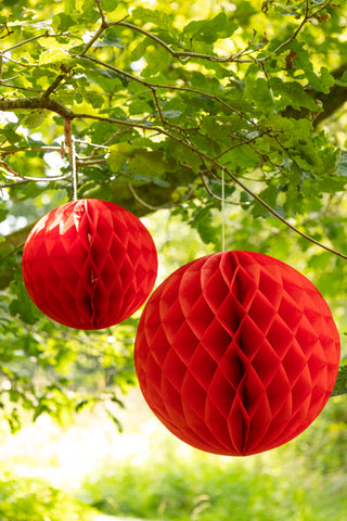 Set Of 2 Red Honeycomb Ball Decorations hanging from tree