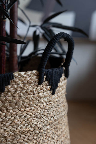 Close-up of the handle on one of the Set Of 2 Seagrass Baskets, styled with a faux plant inside.