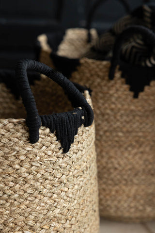 Close-up of the handle on the smaller Seagrass Basket, with the larger basket in the background with a blanket inside.