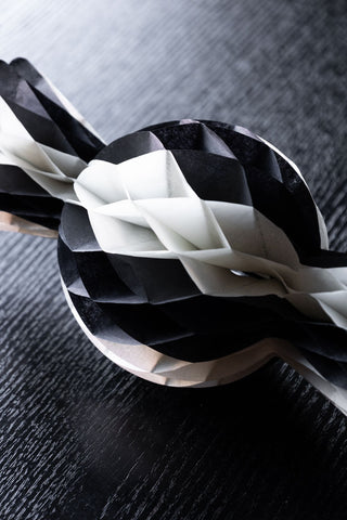 Close-up of one of the Set Of 3 Black & White Honeycomb Sweets styled on a dark wooden table.